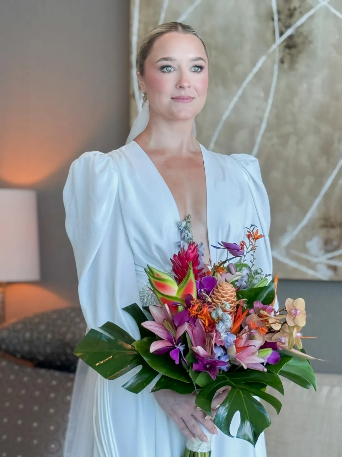 Novia con ramo tropical de lirios, orquídeas y hojas de monstera