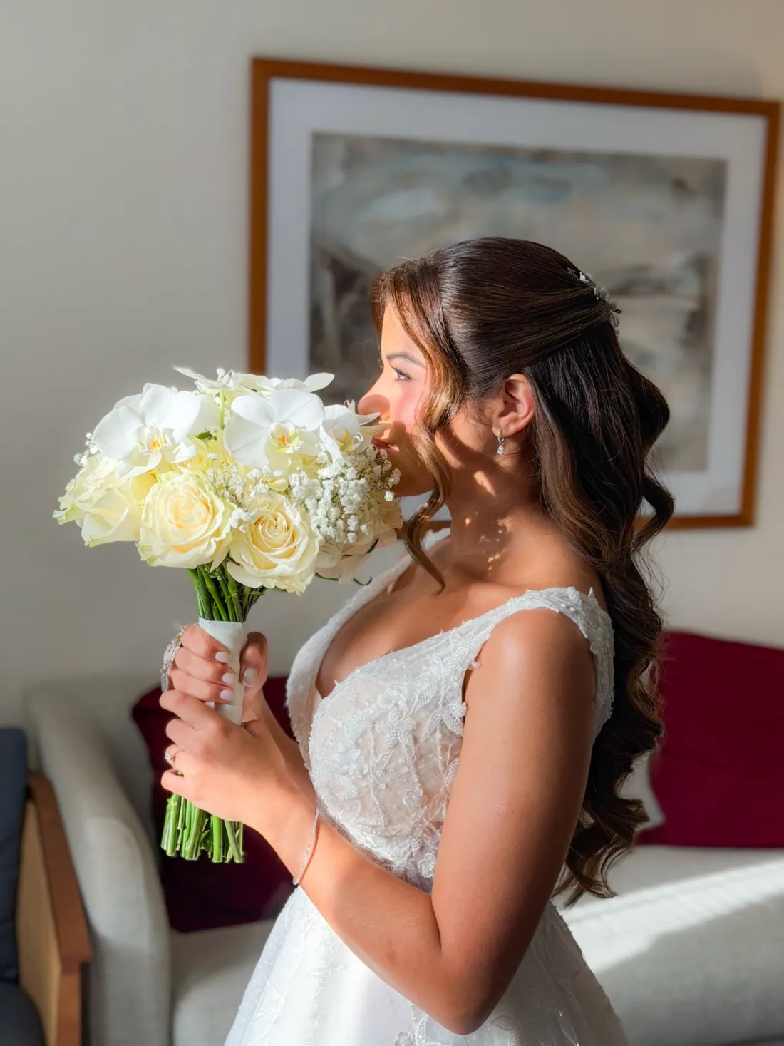 Novia de perfil con ramo de rosas crema, orquídeas blancas y paniculata