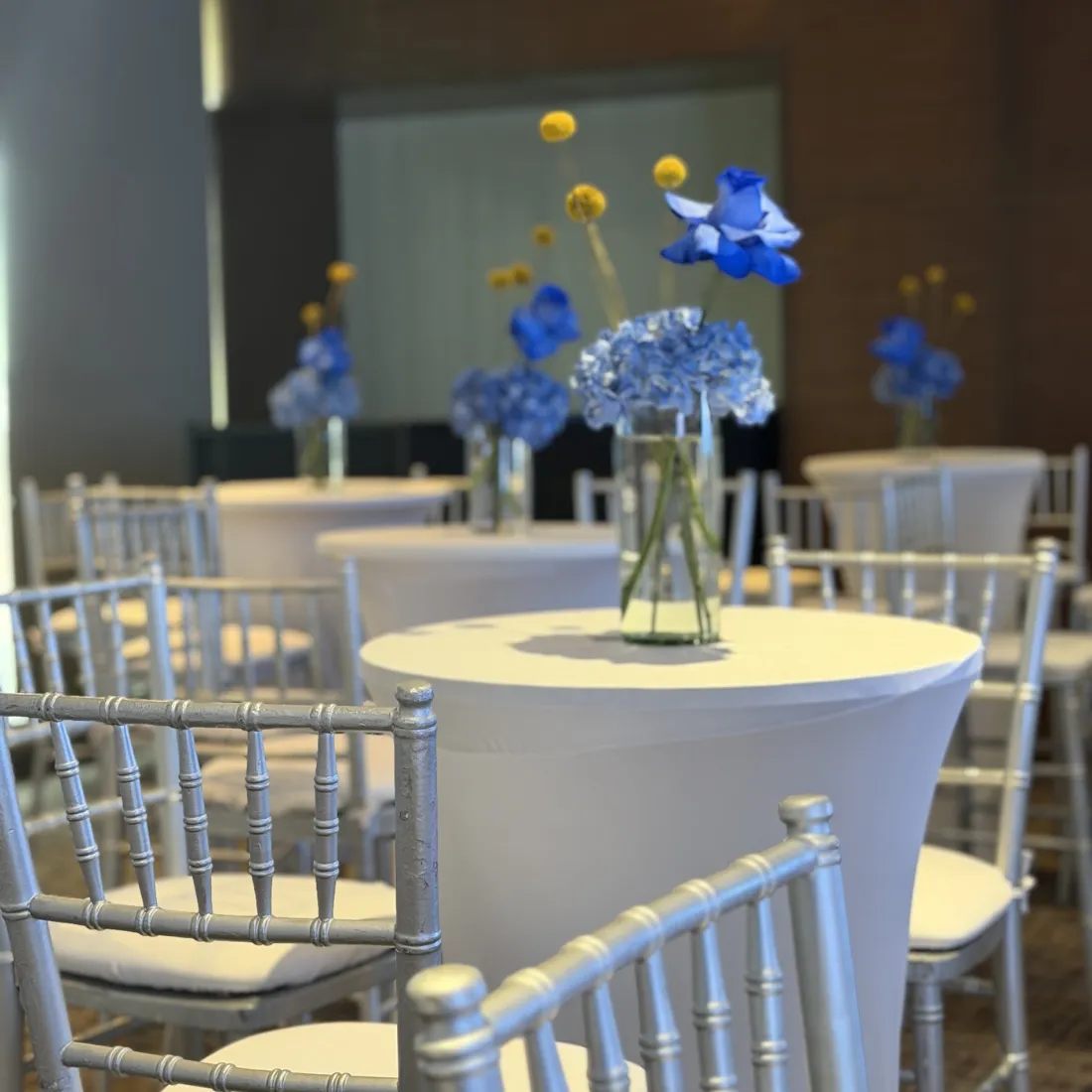 Mesas cóctel con flores azules para evento corporativo